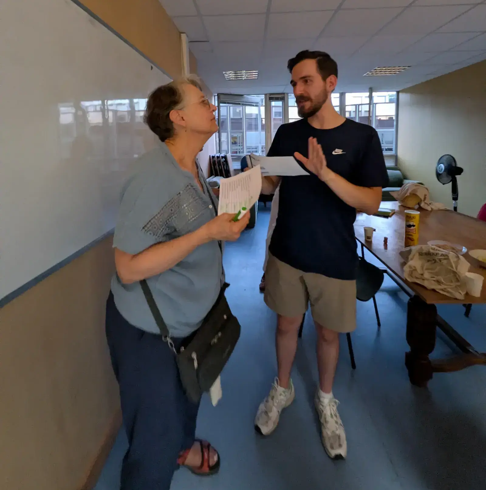 Deux participants échangent, feuille d'activité en main, pendant un jeu de conversation